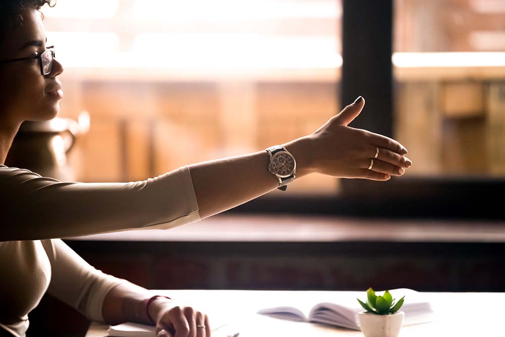 Black woman at work offering a handshake