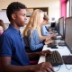 teenage students sitting at a row of computers